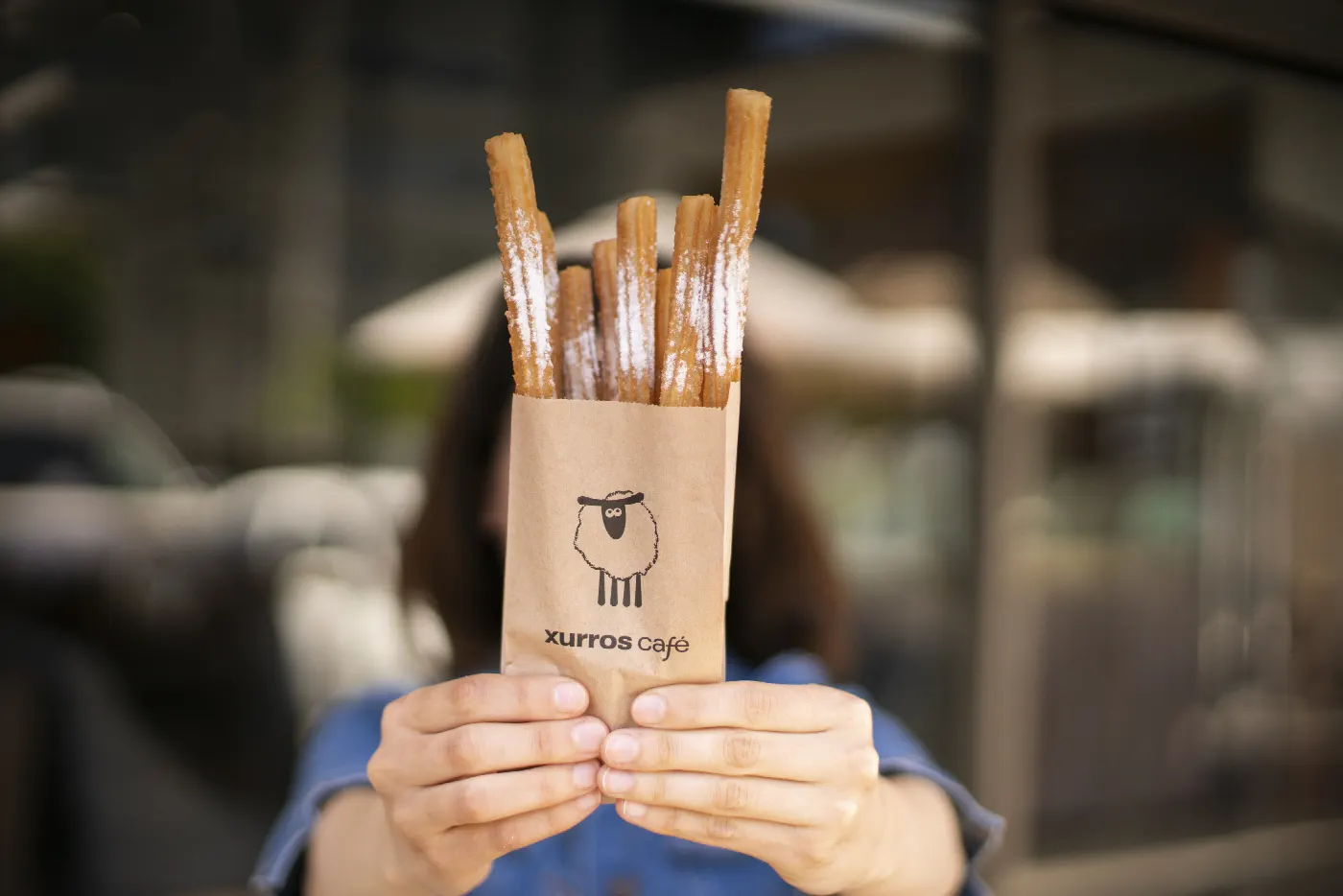 Persona tapándose la cara con un cucurucho de churros Xurros Café